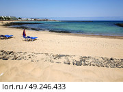 umbrella people footstep coaststone  volcanic spain  water in lanzarote  sky cloud beach  and summer . Стоковое фото, агентство Ingram Publishing / Фотобанк Лори