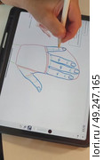 Рука девушки креатора держит пальцами pensil и рисует на планшете ipad pro изображение кисти руки человека в специальной программе для обучения художников для инстаграм и тик ток. Стоковое видео, видеограф Светлана Русских / Фотобанк Лори