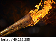 An elaborately designed torch emits bright flames against a dark backdrop, highlighting the detailed engraving and intense glow of the fire. Стоковое AI-изображение, AI-художник Данила Большаков / Фотобанк Лори