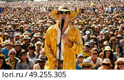 A man wearing a yellow hat stands confidently in front of a diverse crowd, appearing engaged and ready to speak. Стоковое AI-изображение, AI-художник Данила Большаков / Фотобанк Лори