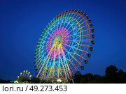 High neon ferris wheel at night in an amusement park Navruz or Anhor in Tashkent, Uzbekistan. (2023 год). Стоковое фото, фотограф Емельянов Евгений Викторович / Фотобанк Лори