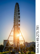 Tashkent, Uzbekistan - August 12, 2023: High ferris wheel at sunset or sunrise with blue sky in an amusement park Navruz or Anhor. Редакционное фото, фотограф Емельянов Евгений Викторович / Фотобанк Лори
