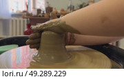 The potter's wheel. A close-up of the hands of a craftsman skillfully working with clay on a potter's wheel, giving it the shape of a clay product. Стоковое видео, видеограф Ирина Старикова / Фотобанк Лори