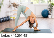 Experienced girl fitness club teacher performs downward facing dog, Adho Mukha Svanasana. Стоковое фото, фотограф Яков Филимонов / Фотобанк Лори