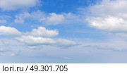Light and fluffy white cumulus clouds scatter across a bright blue sky. Стоковое фото, фотограф EugeneSergeev / Фотобанк Лори