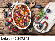 stew meat in plum sauce. meat stew in sauce of autumn plums on a retro background. Стоковое фото, агентство Ingram Publishing / Фотобанк Лори