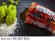 Grilled smoked eel with green apple and citrus on black plate. Стоковое фото, агентство Ingram Publishing / Фотобанк Лори