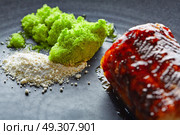 Grilled smoked eel with green apple and citrus on black plate. Стоковое фото, агентство Ingram Publishing / Фотобанк Лори