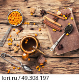 tea with sea-buckthorn. cup with healing tea with berries of sea-buckthorn on wooden retro background. Стоковое фото, агентство Ingram Publishing / Фотобанк Лори