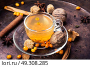 healthy tea with sea-buckthorn. cup with healing tea with sea-buckthorn on wooden retro background. Стоковое фото, агентство Ingram Publishing / Фотобанк Лори