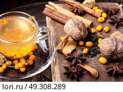 healthy tea with sea-buckthorn. cup with healing tea with sea-buckthorn on wooden retro background. Стоковое фото, агентство Ingram Publishing / Фотобанк Лори