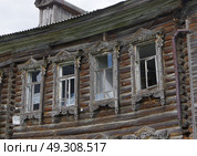 Сохранившиеся наличники на полузаброшенном двухэтажном деревянном доме. Тюменская область, город Тобольск, улица Мусы Джалиля, 3. Редакционное фото, фотограф Алексей Иванов / Фотобанк Лори