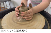 Master class on modeling of clay on a potter's wheel In the pottery workshop. Стоковое видео, видеограф Ирина Старикова / Фотобанк Лори