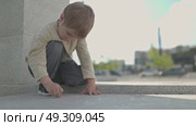 Young child drawing with chalk on pavement. Стоковое видео, видеограф Константин Шишкин / Фотобанк Лори
