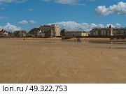 Saint-Malo, Brittany, France, 05.04.2019: View of the promenade and the beach with wooden breakwaters at low tide on a sunny summer day. Редакционное фото, фотограф Ula Ulachka / Фотобанк Лори