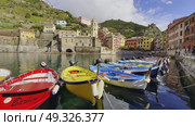 Colorful boats docked in Vernazza harbor with scenic buildings and hills around. Редакционное видео, видеограф Антон Гвоздиков / Фотобанк Лори