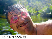Crazy nerd hilarious guy with diving goggles in a lake. Стоковое фото, агентство Ingram Publishing / Фотобанк Лори