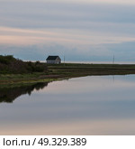 Scenic view of calm river with house in background, Cheticamp, Cabot Trail, Cape Breton Island, Nova Scotia, Canada. Стоковое фото, агентство Ingram Publishing / Фотобанк Лори