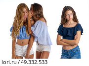 Teen best friends bullying a girl sad apart out of the game on white background. Стоковое фото, агентство Ingram Publishing / Фотобанк Лори