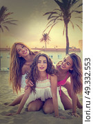Best friends teen girls having fun on a beach sand at sunset. Стоковое фото, агентство Ingram Publishing / Фотобанк Лори