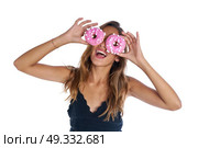 Teen girl holding donuts on her eyes as goggles at white background. Стоковое фото, агентство Ingram Publishing / Фотобанк Лори