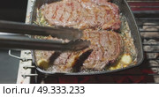 barbecue party, close-up footage of grilling steaks, the meat is stewed in butter with garlic and thyme, spiking pieces of meat on the grill, various vegetables, lots of smoke. Стоковое видео, видеограф Vladimir Drozdin / Фотобанк Лори