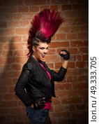 Young punk girl on brick wall background. Стоковое фото, агентство Ingram Publishing / Фотобанк Лори