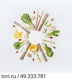 Asian food creative layout round frame on white desk background, top view. Asian cuisine ingredients with soba noodles, vegetables, spices and pak choi. Vegetarian eating and healthy nutrition concept. Стоковое фото, агентство Ingram Publishing / Фотобанк Лори