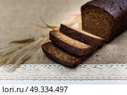 black bread on burlap with ears on a white board. Стоковое фото, агентство Ingram Publishing / Фотобанк Лори