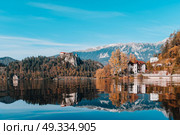 Lake Bled in the Alpine mountains in autumn under blue sky. Стоковое фото, агентство Ingram Publishing / Фотобанк Лори