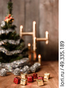 Christmas decorative tree is adorned with rain stands on the table with a lit lamp lights. Стоковое фото, агентство Ingram Publishing / Фотобанк Лори
