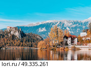 Lake Bled in the Alpine mountains in autumn under blue sky. Стоковое фото, агентство Ingram Publishing / Фотобанк Лори