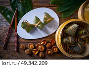 Zongzi Glutinous sticky Rice Dumplings recipe wrap with bamboo leaves asian food. Стоковое фото, агентство Ingram Publishing / Фотобанк Лори