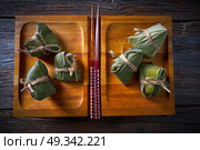 Zongzi Glutinous sticky Rice Dumplings recipe wrap with bamboo leaves asian food. Стоковое фото, агентство Ingram Publishing / Фотобанк Лори