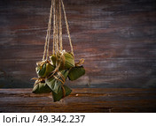 Zongzi Glutinous sticky Rice Dumplings recipe wrap with bamboo leaves asian food. Стоковое фото, агентство Ingram Publishing / Фотобанк Лори