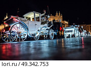 The old square of the night krakow with luminous horse-drawn carriages. Стоковое фото, агентство Ingram Publishing / Фотобанк Лори