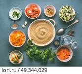 Food flat lay with couscous and vegetarian cooking ingredients in bowls on gray background, top view. Стоковое фото, агентство Ingram Publishing / Фотобанк Лори