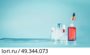 Cosmetic bottle products with liquid, pipette at blue background, front view.  Essence, toner or extract serum on table, front view. Beauty and modern skin care concept with copy space. Стоковое фото, агентство Ingram Publishing / Фотобанк Лори