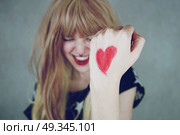 Happy young woman with a heart painted in her hand. Стоковое фото, агентство Ingram Publishing / Фотобанк Лори