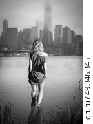 girl in the evening into the Hudson comes against the backdrop of Manhattan. Black and white photography. Стоковое фото, агентство Ingram Publishing / Фотобанк Лори