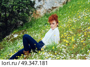 Young redhead woman in a field of flowers . Стоковое фото, агентство Ingram Publishing / Фотобанк Лори