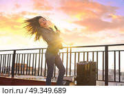 Band girl singing karaoke outdoor at roof terrace . Band girl singing karaoke outdoor at roof terrace in the city. Стоковое фото, агентство Ingram Publishing / Фотобанк Лори
