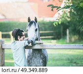 Young happy guy laughs and hugs his horse at summer outdoor nature. Стоковое фото, агентство Ingram Publishing / Фотобанк Лори