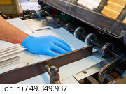 Flexo printing machine in a print factory. Flexo printing machine in a print factory operator hand detail. Стоковое фото, агентство Ingram Publishing / Фотобанк Лори