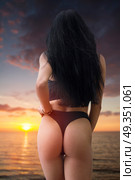 woman in a swimsuit is standing ass at sunset. woman in a swimsuit is standing ass. Стоковое фото, агентство Ingram Publishing / Фотобанк Лори