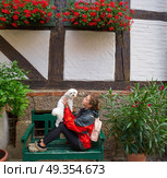Girl tourist holding Maltese bichon dog in Germany. Girl tourist holding Maltese bichon puppy dog in Germany. Стоковое фото, агентство Ingram Publishing / Фотобанк Лори