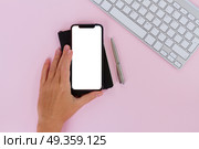 WARSAW, POLAND - DECEMBER 02, 2017: Someone hand holding New Iphone X mobile phone with cup of colorful apps icons. New Iphone X. New Iphone X. Редакционное фото, агентство Ingram Publishing / Фотобанк Лори