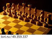 Chessboard with figures on dark background. Chessboard with figures. Стоковое фото, агентство Ingram Publishing / Фотобанк Лори
