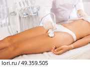 Aesthetician administering high frequency ultrasound procedure on woman thighs. Стоковое фото, фотограф Яков Филимонов / Фотобанк Лори