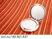 Collapsible mirror on a bright background. Small mirror. Стоковое фото, агентство Ingram Publishing / Фотобанк Лори